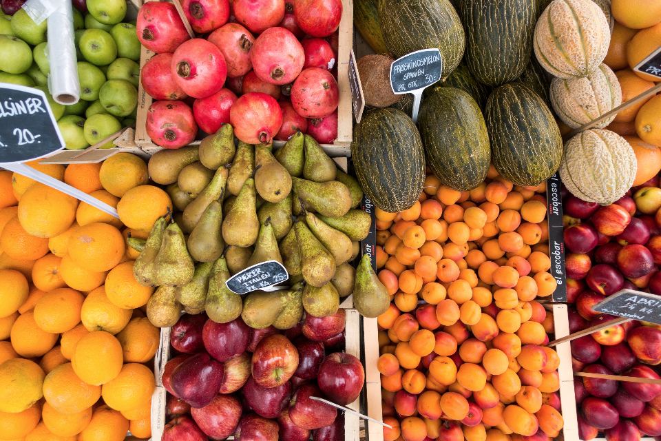 Étal de fruits frais : oranges, poires, grenades et melons