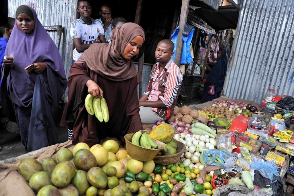 Vendeuse de bananes et d'avocats sur un marché