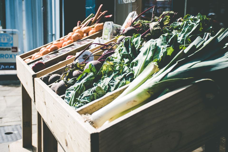Caisses de légumes verts et de poireaux devant une épicerie